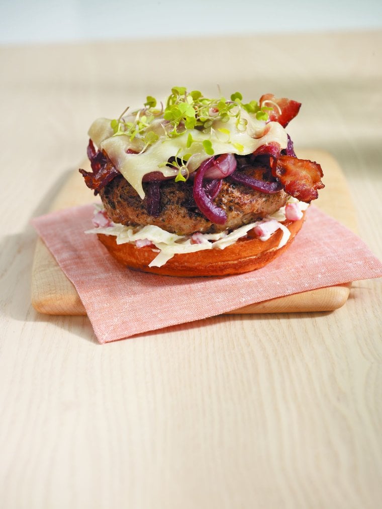 Grilled Australian lamb burger with red wine-braised onions, applewood-smoked bacon and swiss cheese topped with apple fennel yogurt remoulade