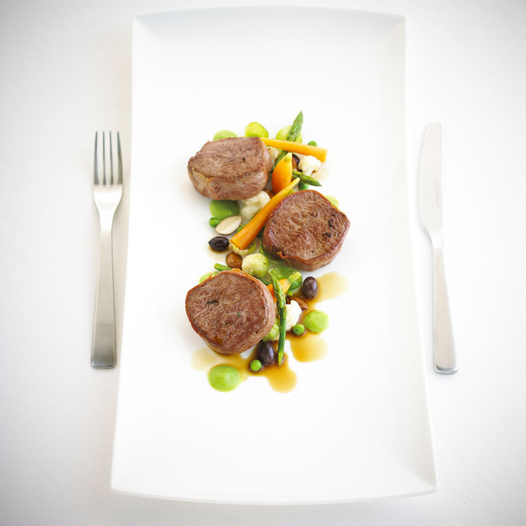 Seared lamb medallions with almond and mint pea cream and baby vegetables