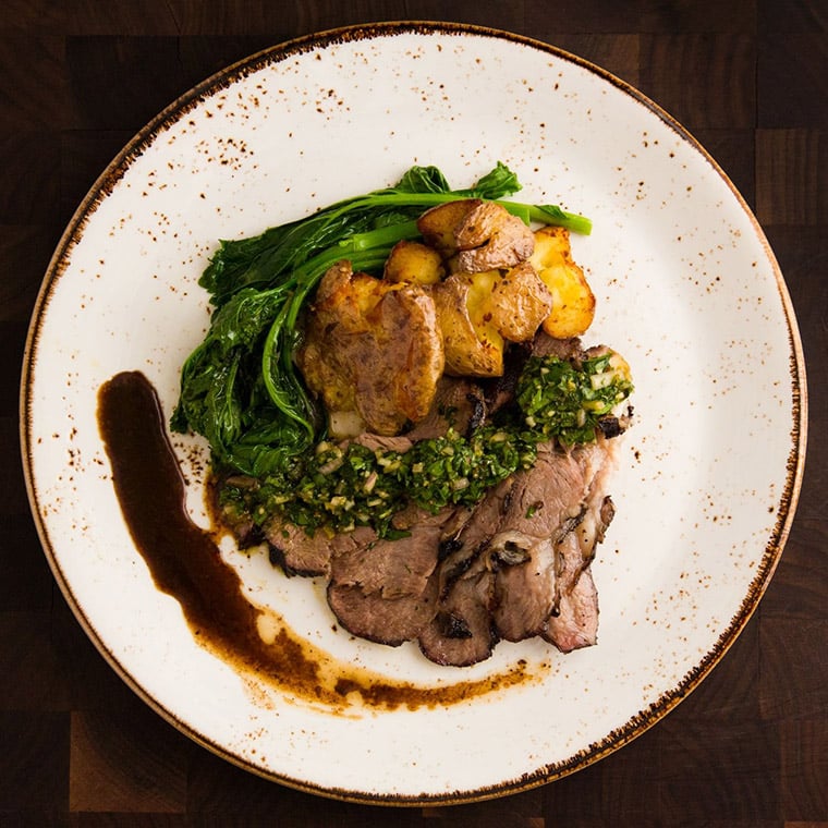 Slow roasted Australian lamb with roasted potatoes, rapini & gremolata
